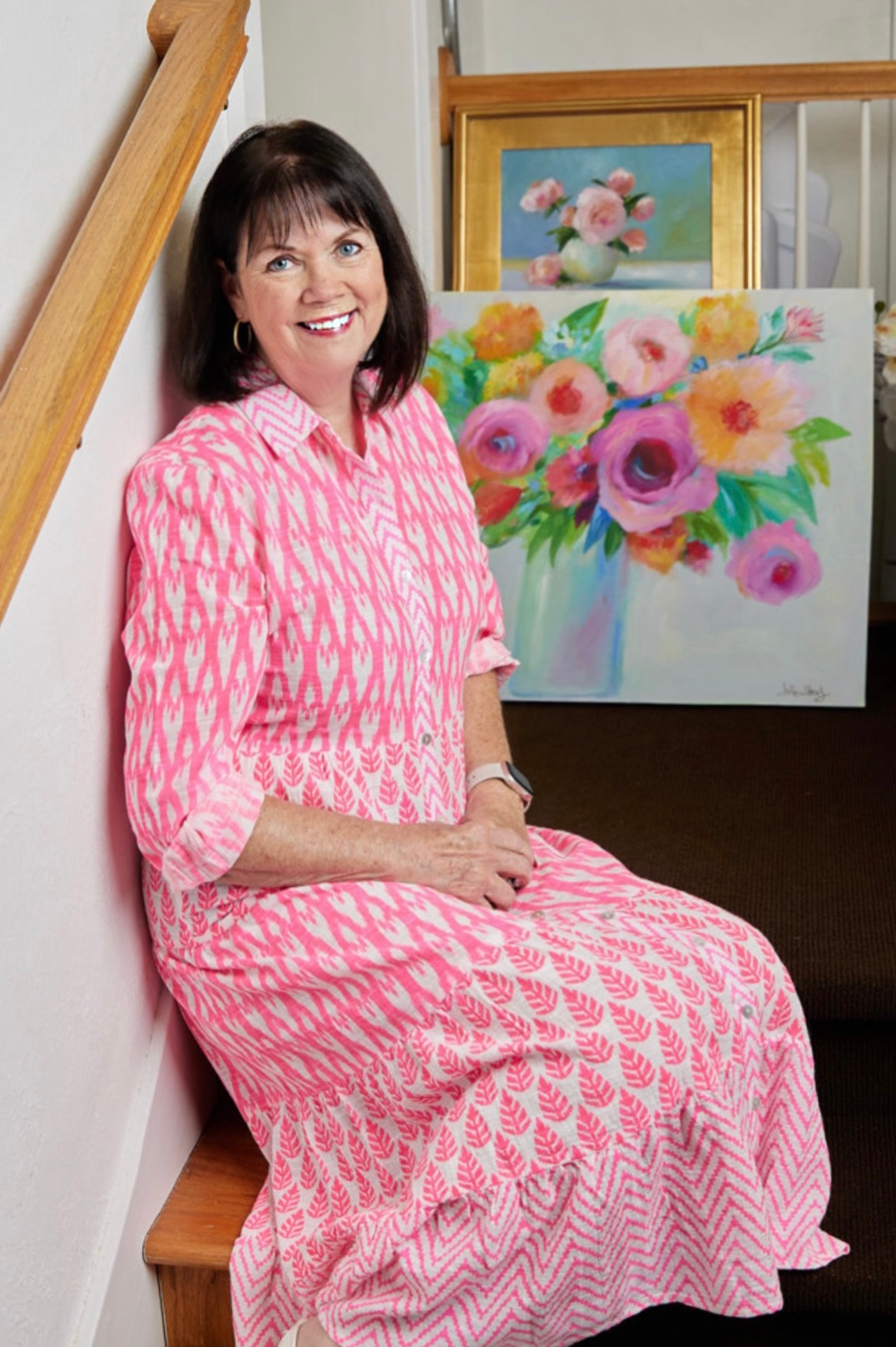 Julie Shealy in Pink Patterned Shirt Dress with Artwork Behind Her